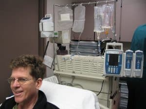 Steve in hospital bed, machines behind him.